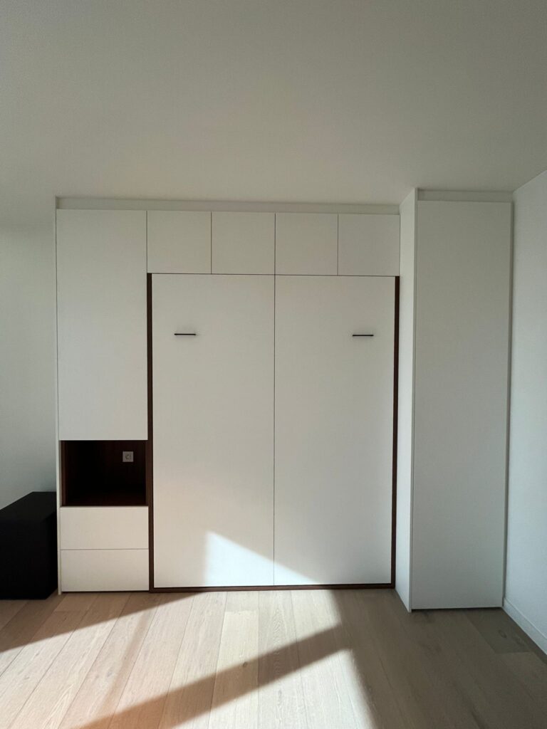 Opklapbed dicht in logeerkamer met nachttafel