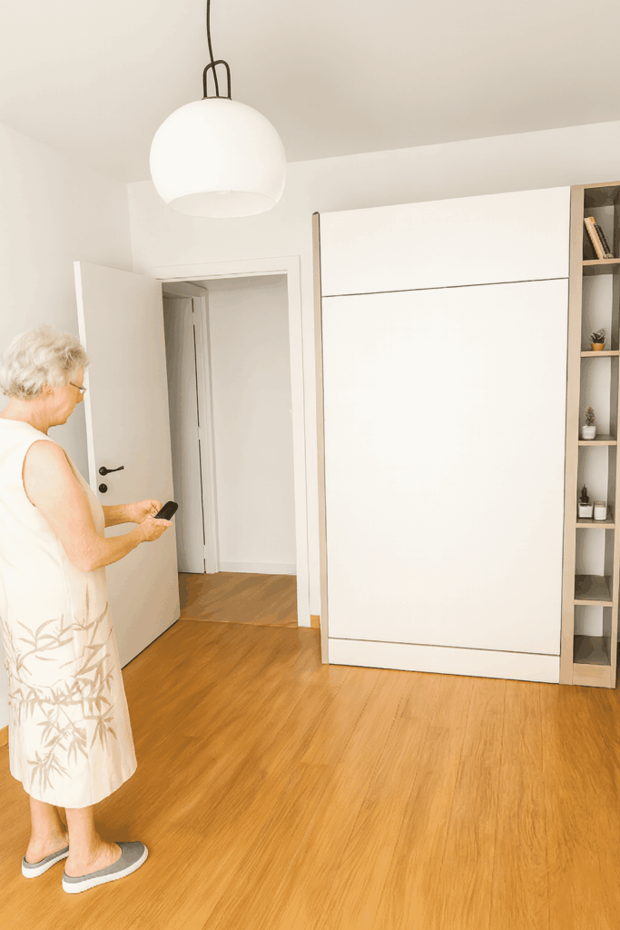 Boone elektrisch opklapbed met oude dame die het bed bedient.